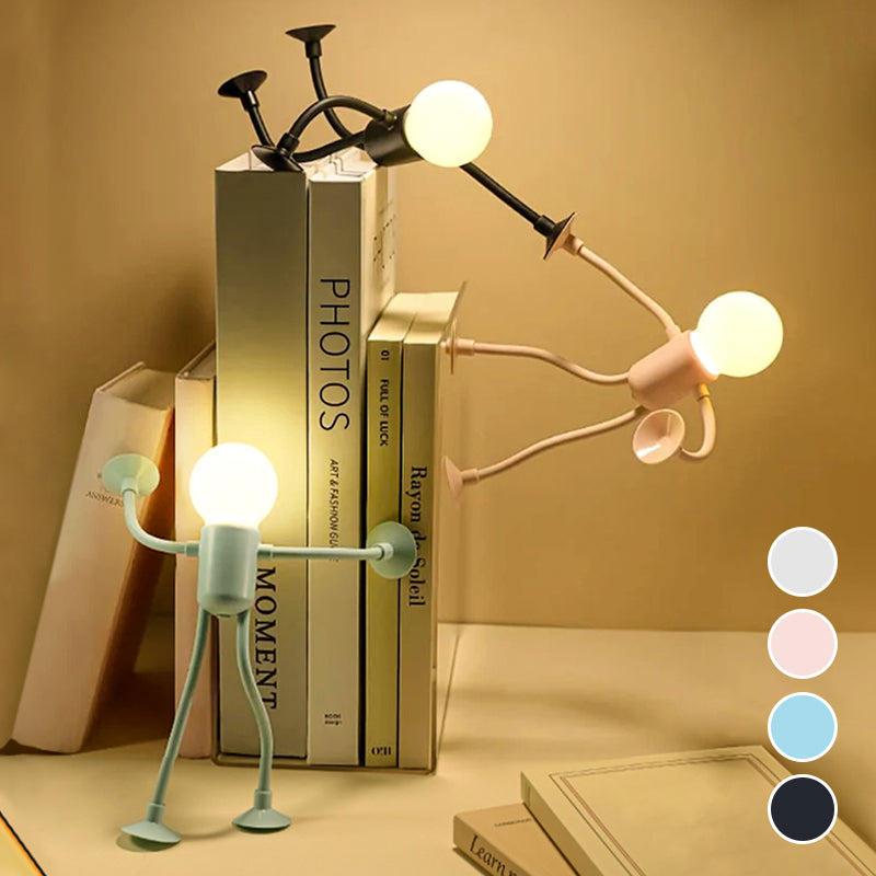 Three glowing figure lamps leaning around a stack of books on a desk.