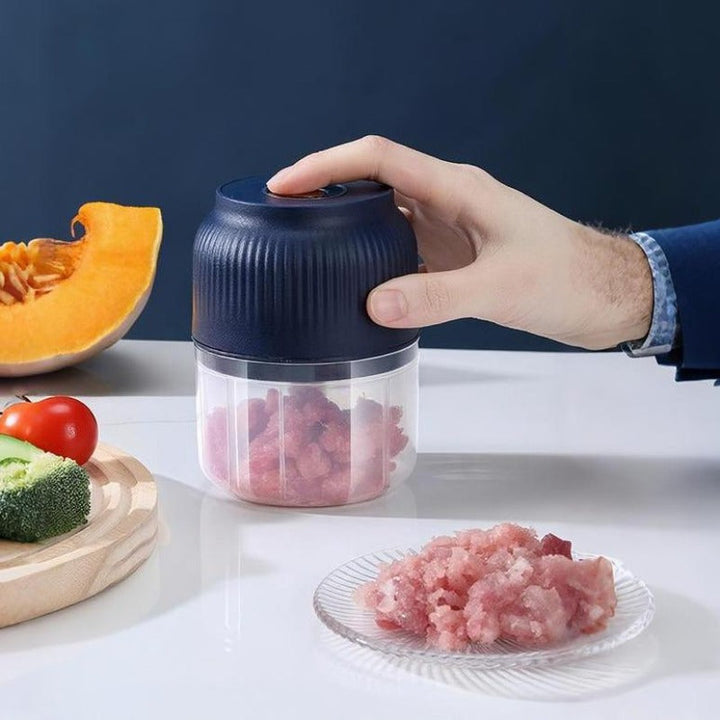 USB Rechargeable Mini Food Chopper with a blue transparent bowl on a table, with minced pork inside.