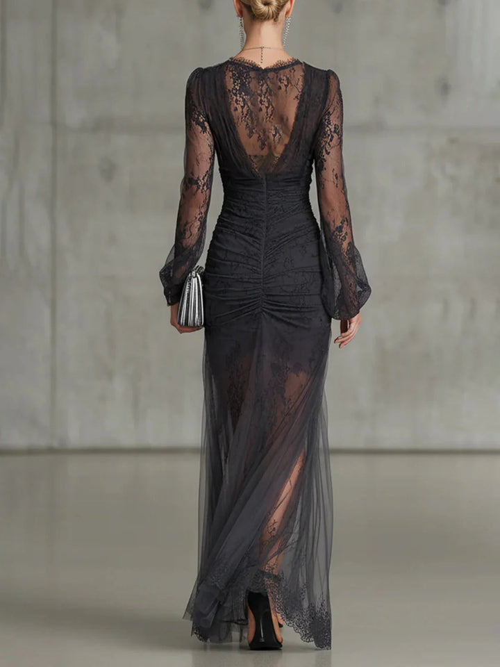 Black lace gown back view with a sheer lace back, ruched center seam and flowing tulle hem.