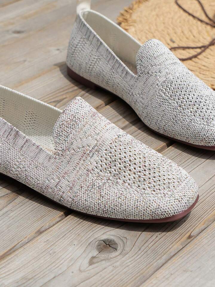 Gray knit slip-on flats with textured mesh toes and a rounded toe.