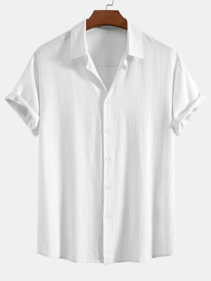 White short sleeve shirt with subtle woven texture on a wooden hanger, front view with cuffed sleeves.