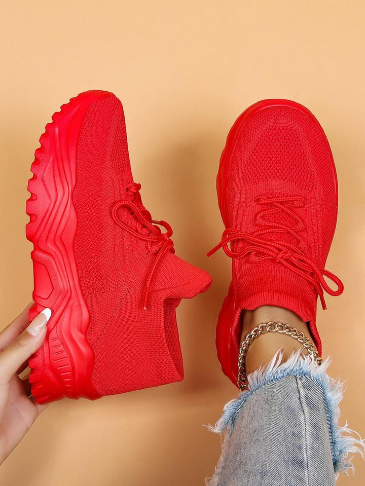 Solid red knit sneakers with red laces and chunky red soles, top-down view.