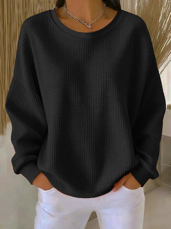 Black waffle-knit crew neck sweater with a relaxed fit and ribbed cuffs.