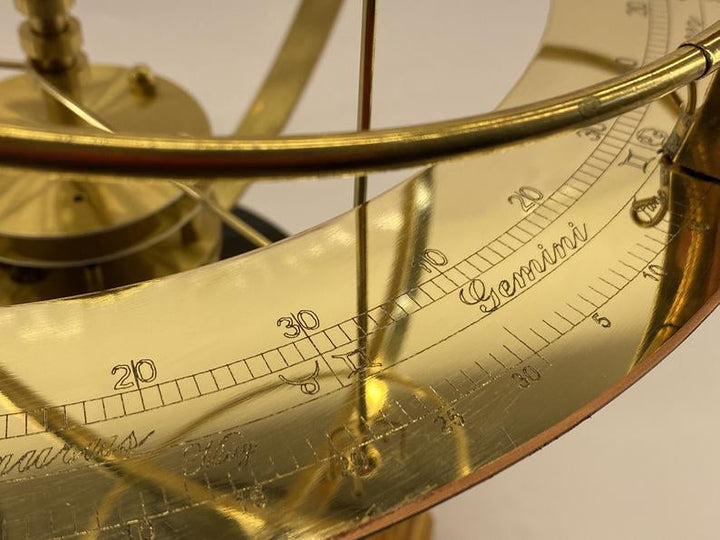 Detail of the engraved brass zodiac ring with degree scale markings and the Gemini section.