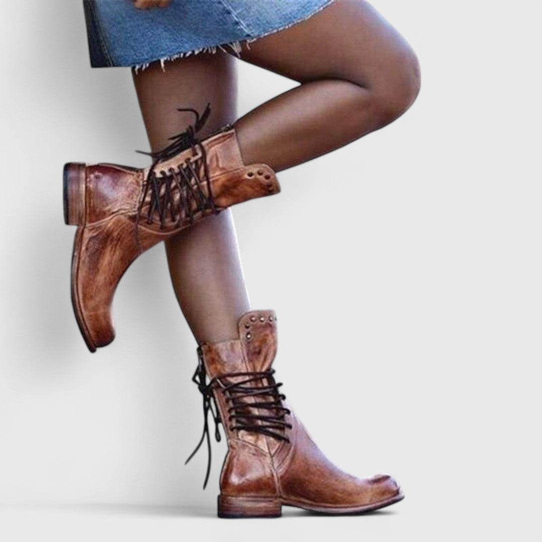 Brown lace-up boots with studded cuffs worn with a denim skirt.