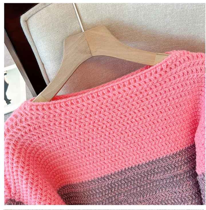 Rosa und grauer Strickpullover auf Holzkleiderbügel, Nahaufnahme, weiches Material.