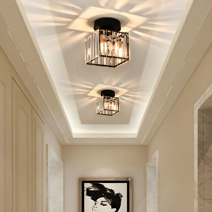 Black square ceiling light with crystal panels glowing on a recessed hallway ceiling.