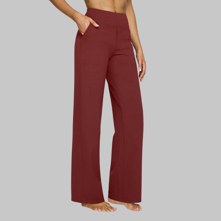 Women's burgundy red high-waist straight-leg pants on a model, side view with one hand in the pocket.
