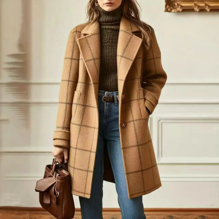 Woman wearing the camel checked coat with dark check lines over an olive turtleneck and jeans 10