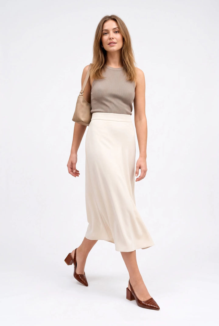 Model walking in brown croc-embossed block heel slingbacks with a cream midi skirt and tan shoulder bag 10
