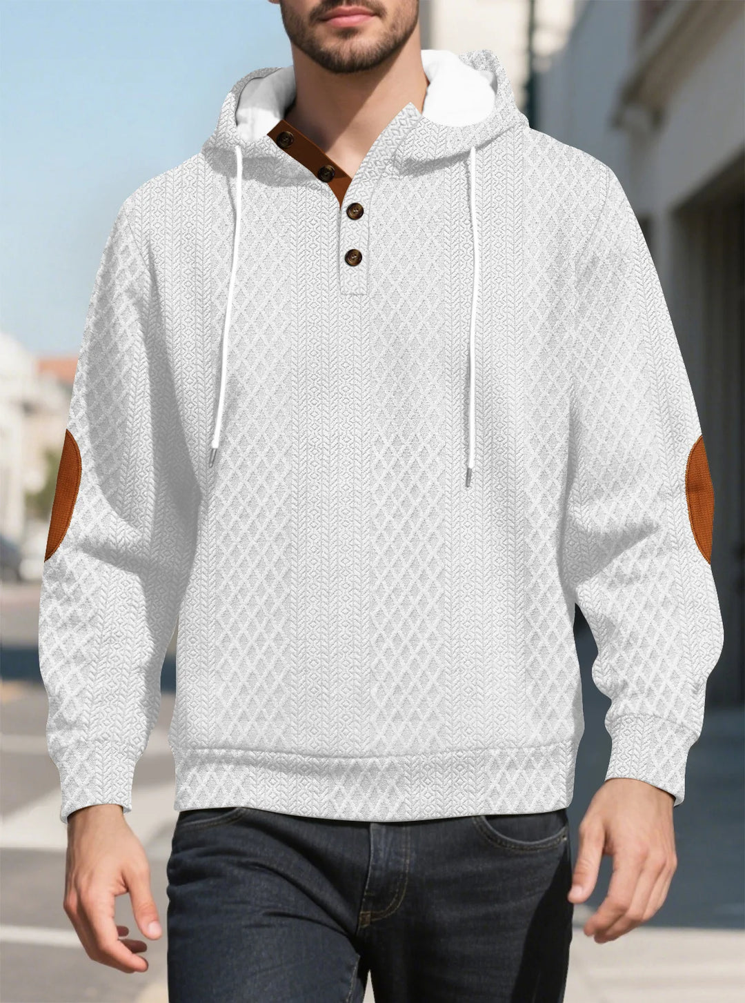 Front view of a man walking in a white diamond-textured hoodie with brown elbow patches on a sunny street 10