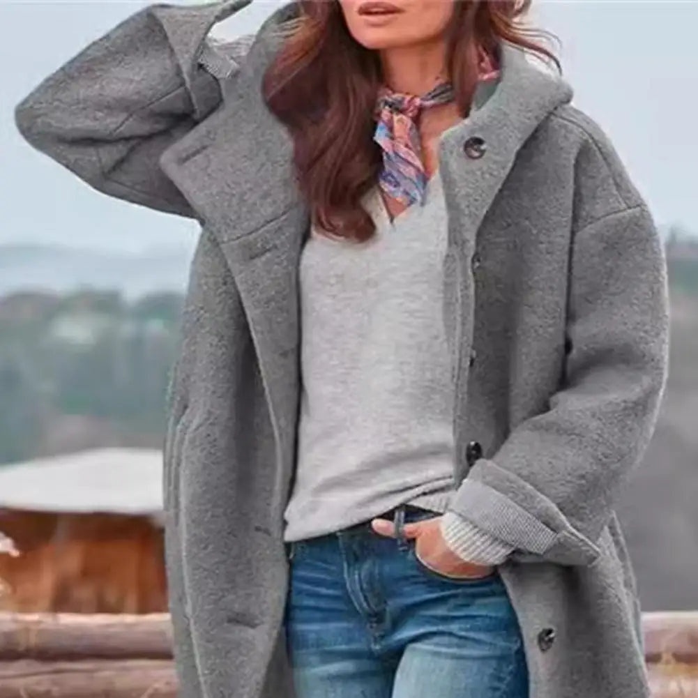 Close-up of the gray hooded coat's textured fabric, buttons and rolled striped cuff 10