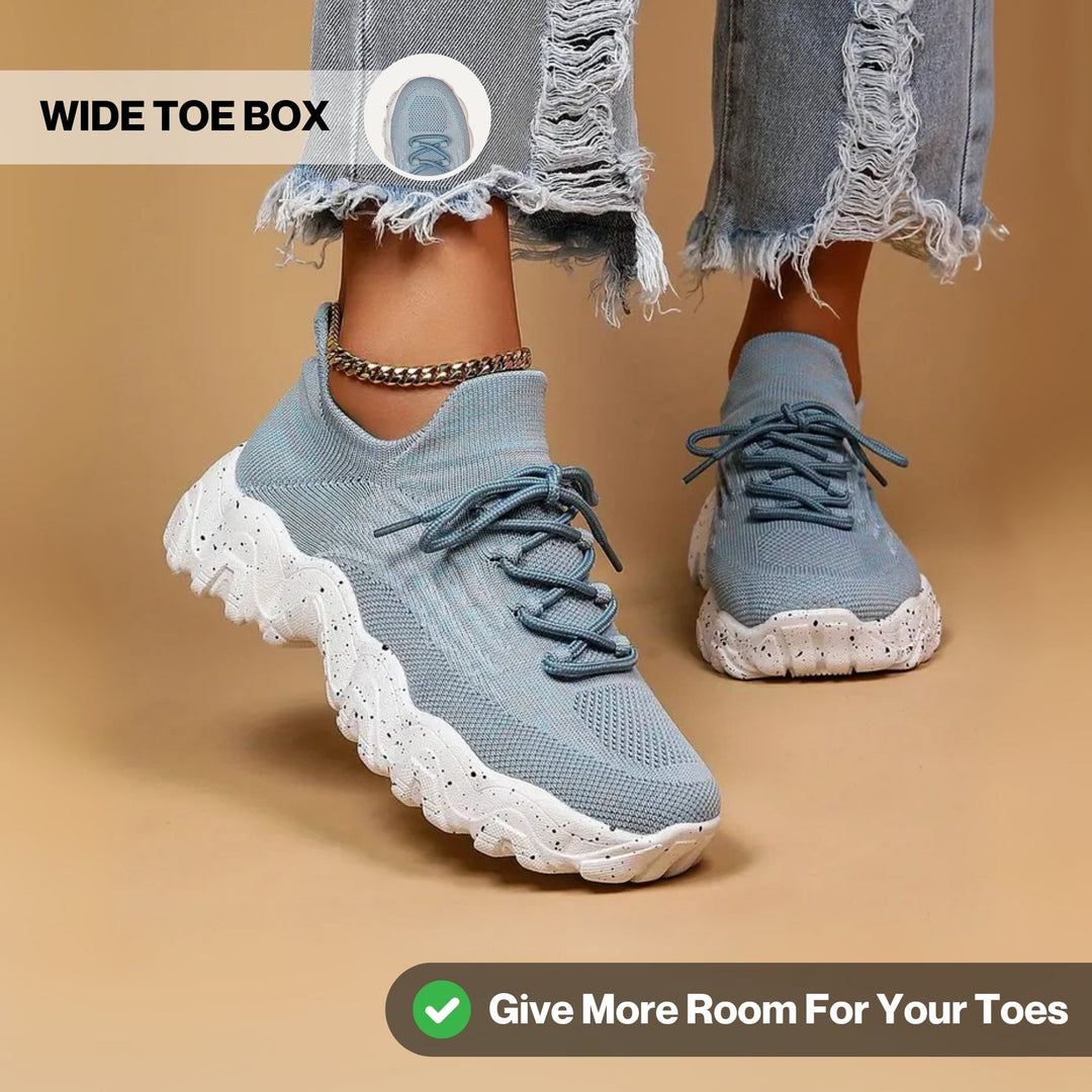 Another view of light blue knit sneakers with chunky speckled white soles and a roomy toe box.
