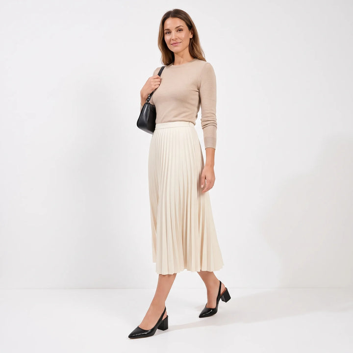 Model walking in black croc-embossed block heel slingbacks with a pleated cream midi skirt and black shoulder bag 11