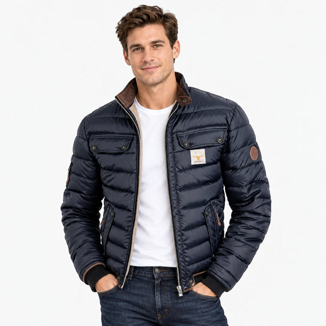 Smiling man wearing the navy quilted jacket open over a white tee and dark jeans 11