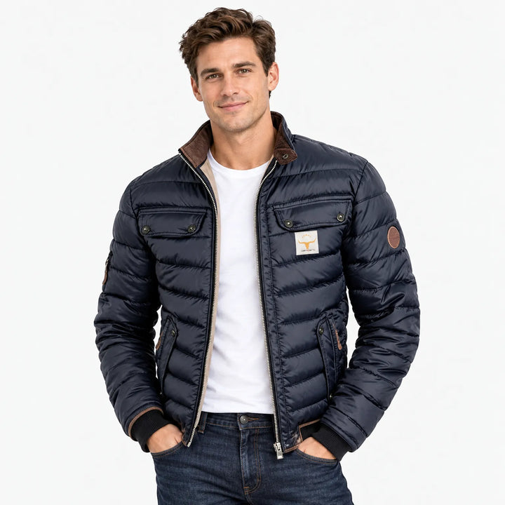 Smiling man wearing the navy quilted jacket open over a white tee and dark jeans 11