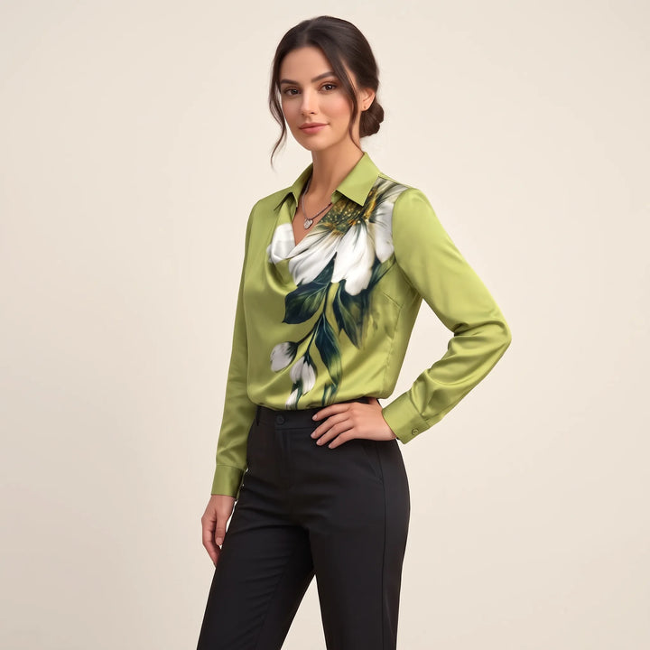 Studio side view of the green floral blouse with white flowers, hand on hip, black trousers 11