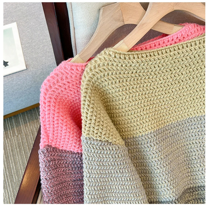 Zwei gestrickte Pullover, rosa und beige, auf Holzkleiderbügeln, gemütliche Wintermode.