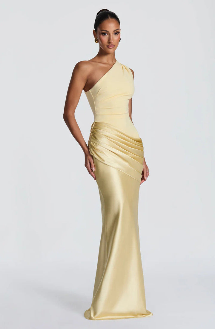 Angled front view of the pale yellow satin maxi dress, highlighting the gathered hip drape and glossy flared skirt. 26