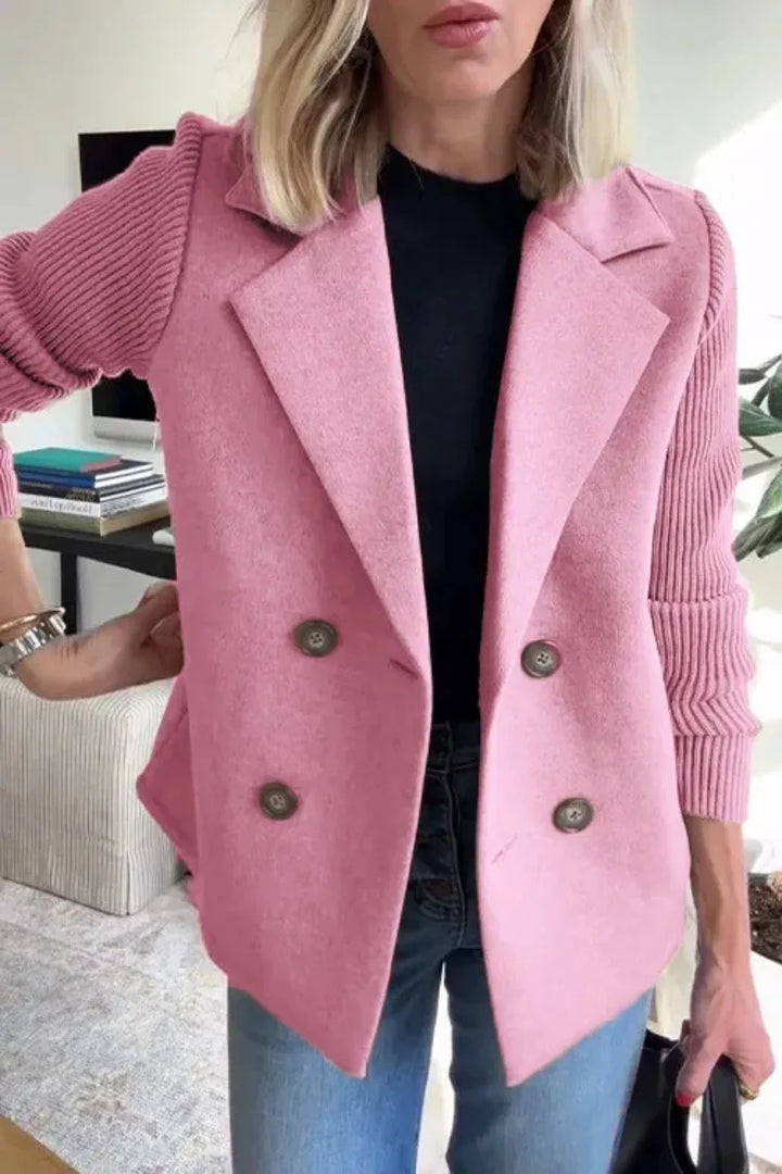 Close-up of pink jacket with wide lapels, four buttons and ribbed knit sleeves over black top 12