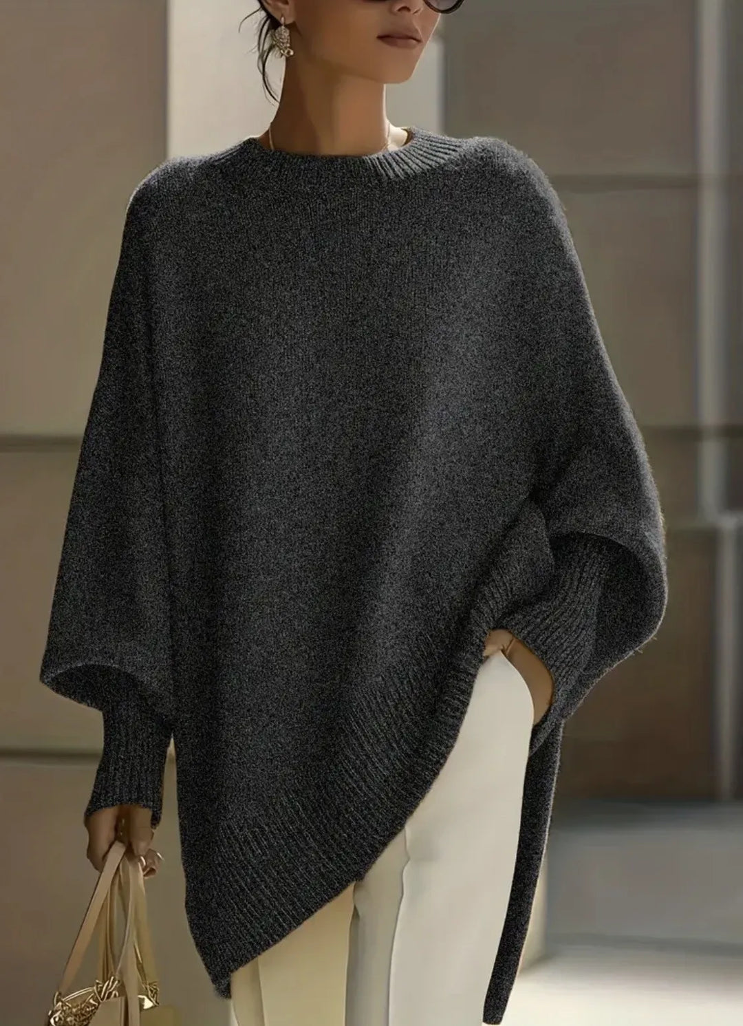 Dark heather gray knit sweater with ribbed cuffs and hem, worn with cream pants and a handbag 12
