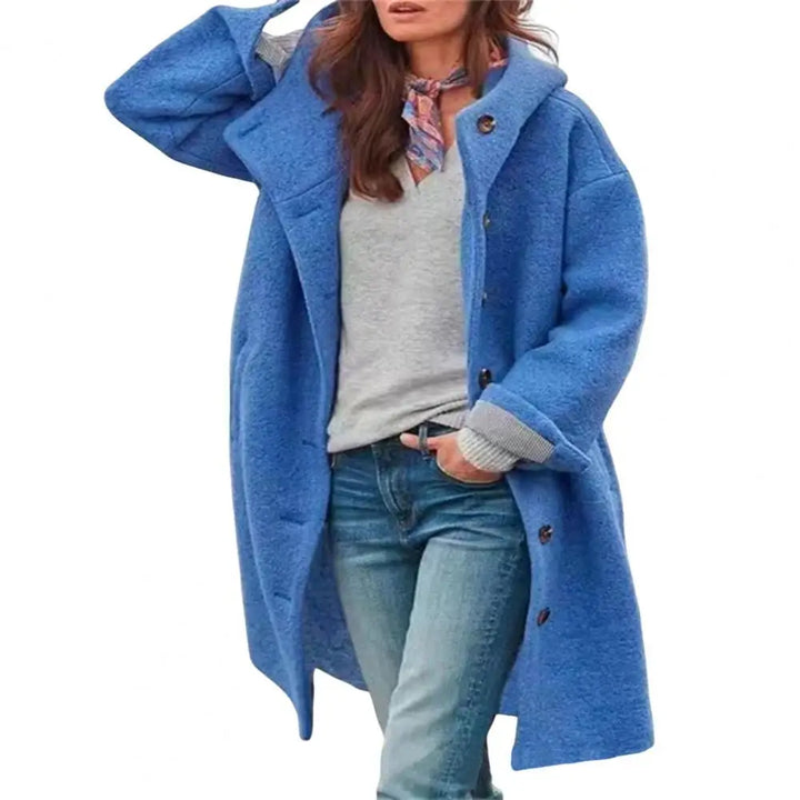 Blue hooded coat styled with a colorful scarf and jeans against a plain white background 12