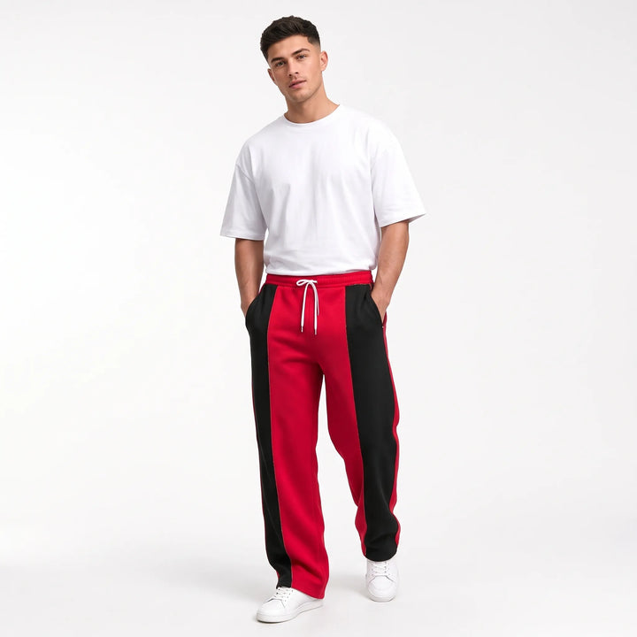 Model in red and black paneled sweatpants with white drawstring, tee and sneakers 12
