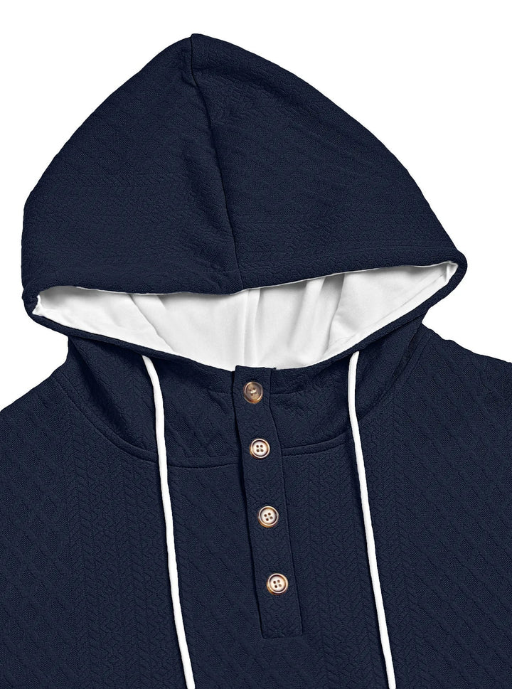 Close-up of a navy hoodie's hood and four-button placket with white drawstrings and textured knit 12