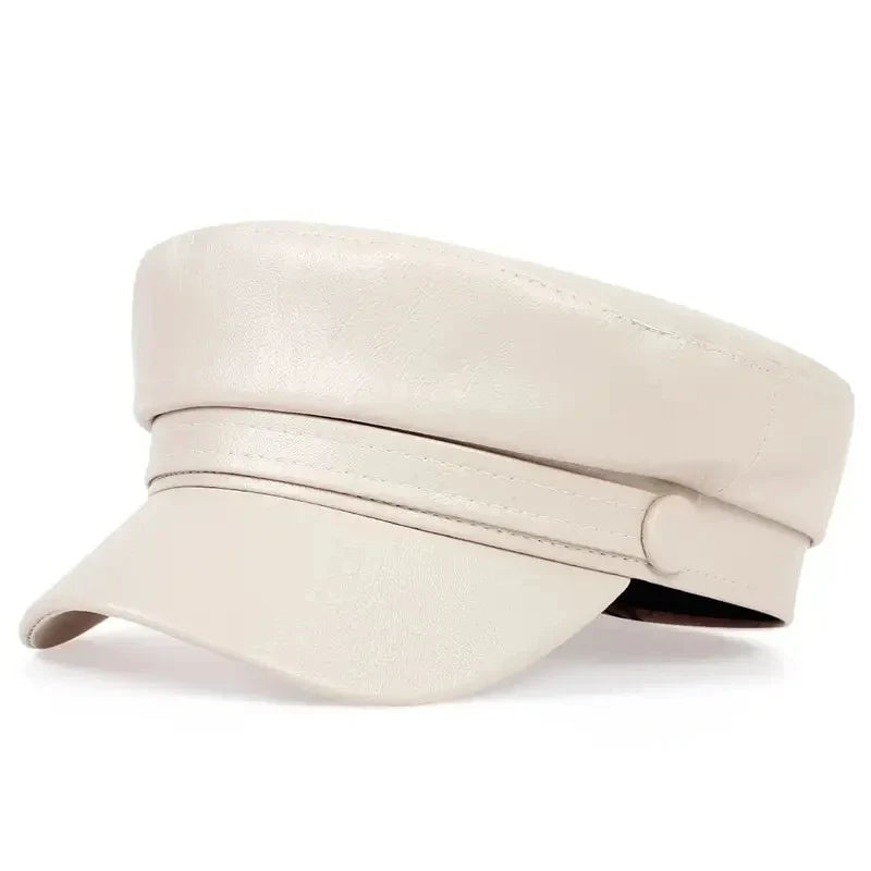 Cream faux leather baker boy cap in angled view with curved visor and covered button 12