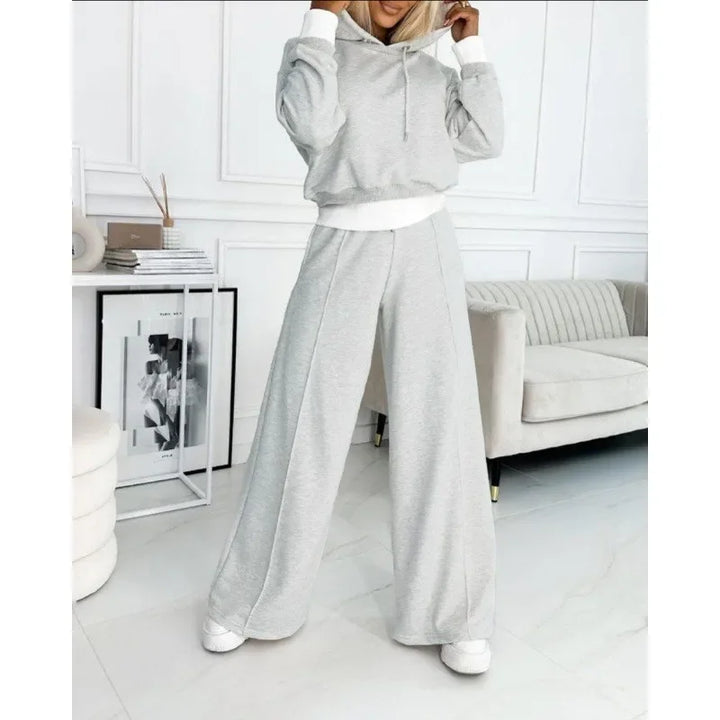 Full-length model in a light gray hoodie and wide-leg pants with white cuffs and waistband trim 12