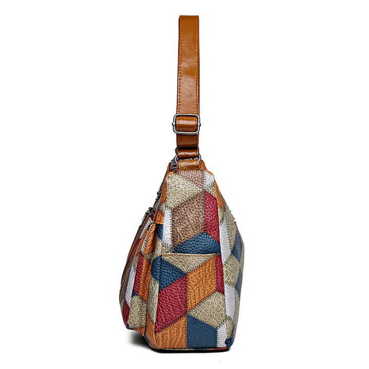 Side view of the bag showing the patchwork panels, a slip pocket and the brown strap with its adjustable metal buckle. 11