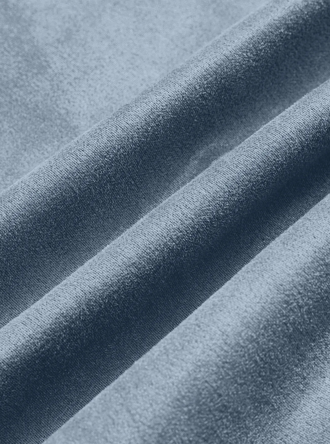 Close-up of the blue jacket fabric draped in soft folds, showing its fine brushed texture 12