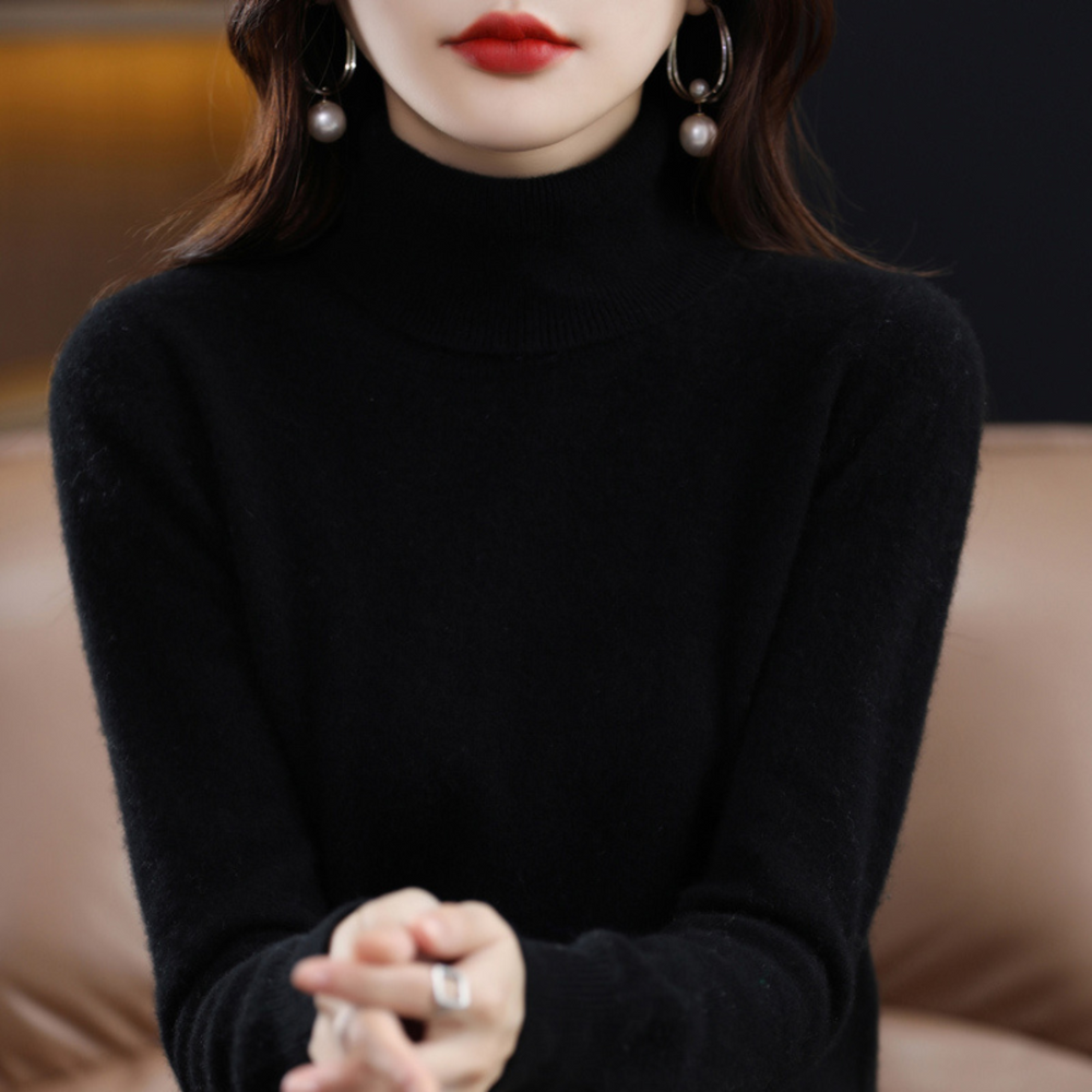 Black cashmere mock-neck sweater detail with a soft fuzzy knit and pearl earrings.