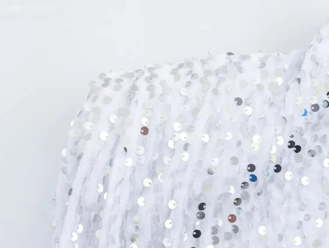 Close-up of white fabric with silver sequins at the shoulder of the dress 13