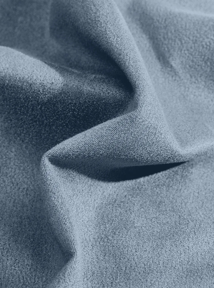 Extreme close-up of the blue suede-look fabric gathered in a fold, showing its fuzzy surface 13