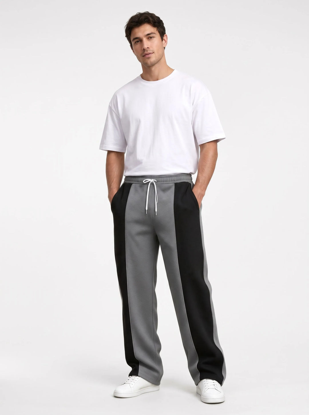 Model in gray and black paneled sweatpants with a soft smooth finish, white tee and sneakers 13