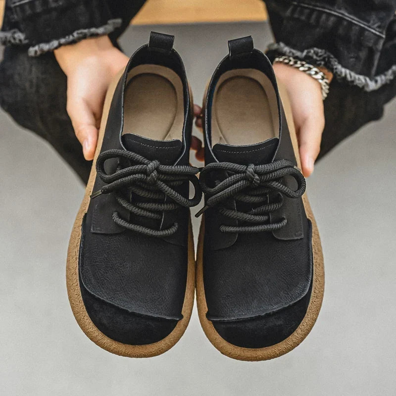 Pair of black lace-up shoes held in two hands, showing insoles and toe caps 13