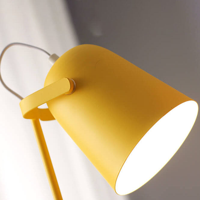 Close-up of the yellow bucket-shaped lampshade, its pivot arm and white cord, with light glowing inside 2