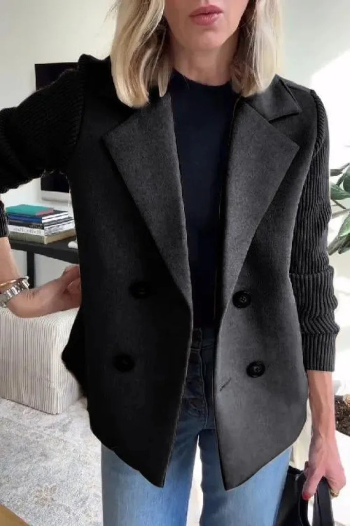 Close-up of black jacket with wide lapels, dark buttons and ribbed knit sleeves, worn with jeans 13