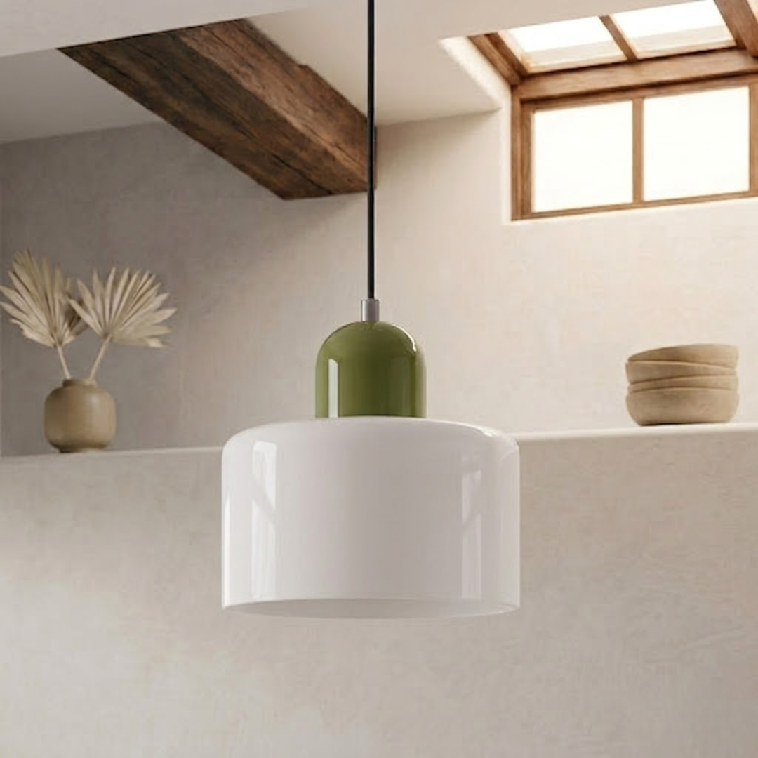 Glossy white drum shade with a green rounded cap, suspended from a black cord in a bright plastered room. 20