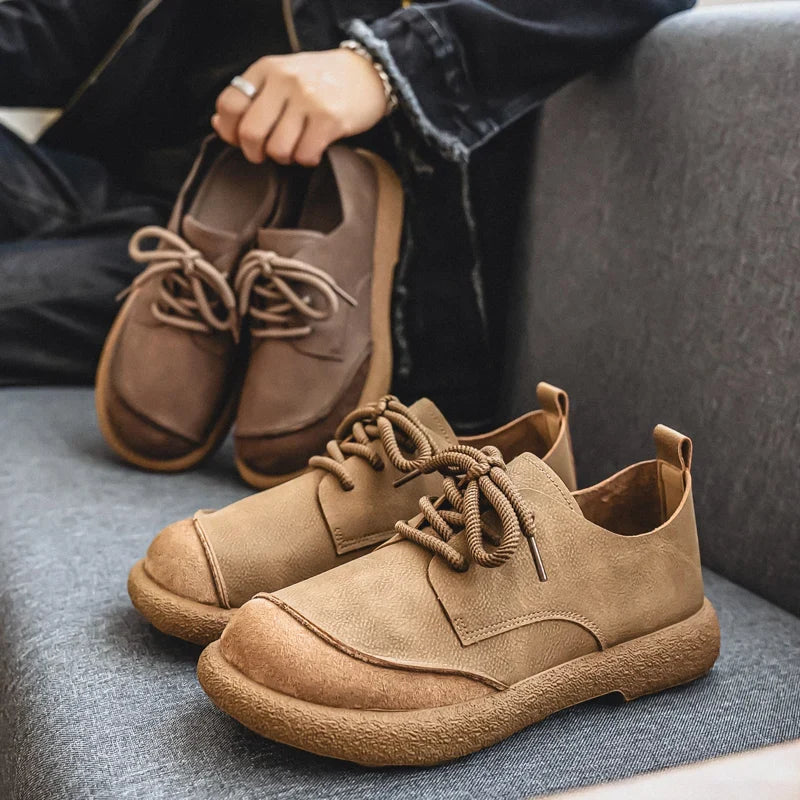 Khaki lace-up shoes on a gray sofa, with a brown pair held in the background 14