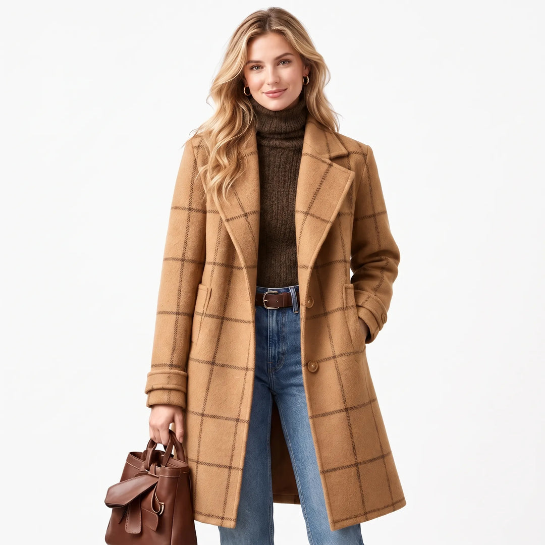 Blonde model wearing the camel checked coat with a brown turtleneck, jeans and leather tote on white 14