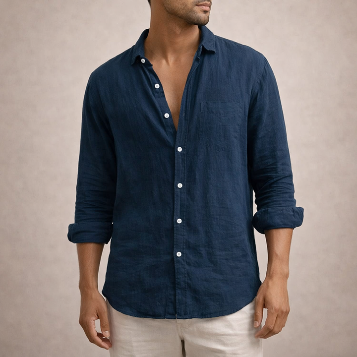 Model in the navy linen shirt, showing a chest pocket, white buttons and rolled sleeves.