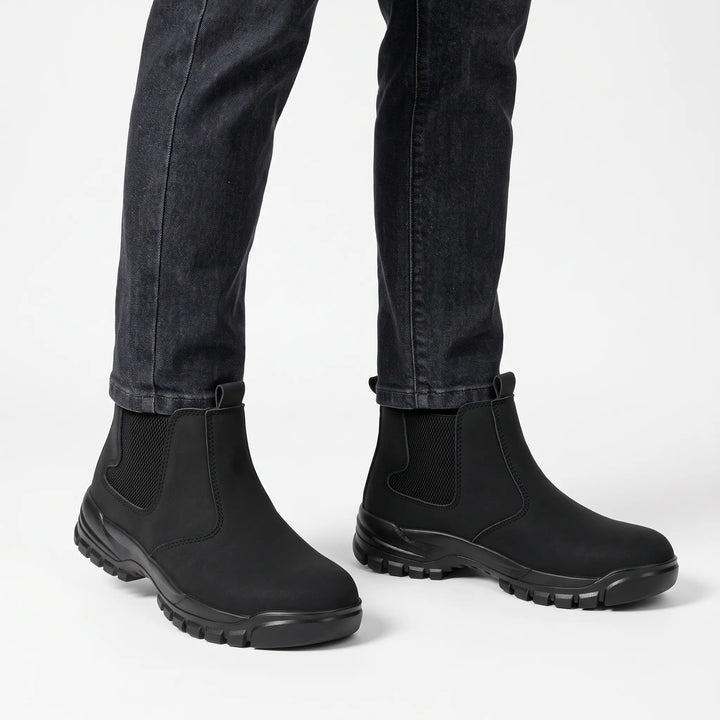 Black boots worn with dark gray jeans against a plain white background 15
