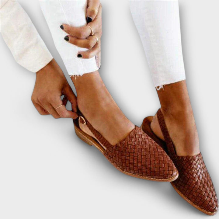 Brown woven leather moccasins for women with a buckled slingback strap, shown with one shoe beside it.