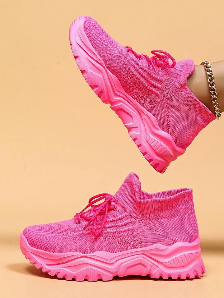 Hot pink knit sock sneakers with matching pink chunky soles, side view.