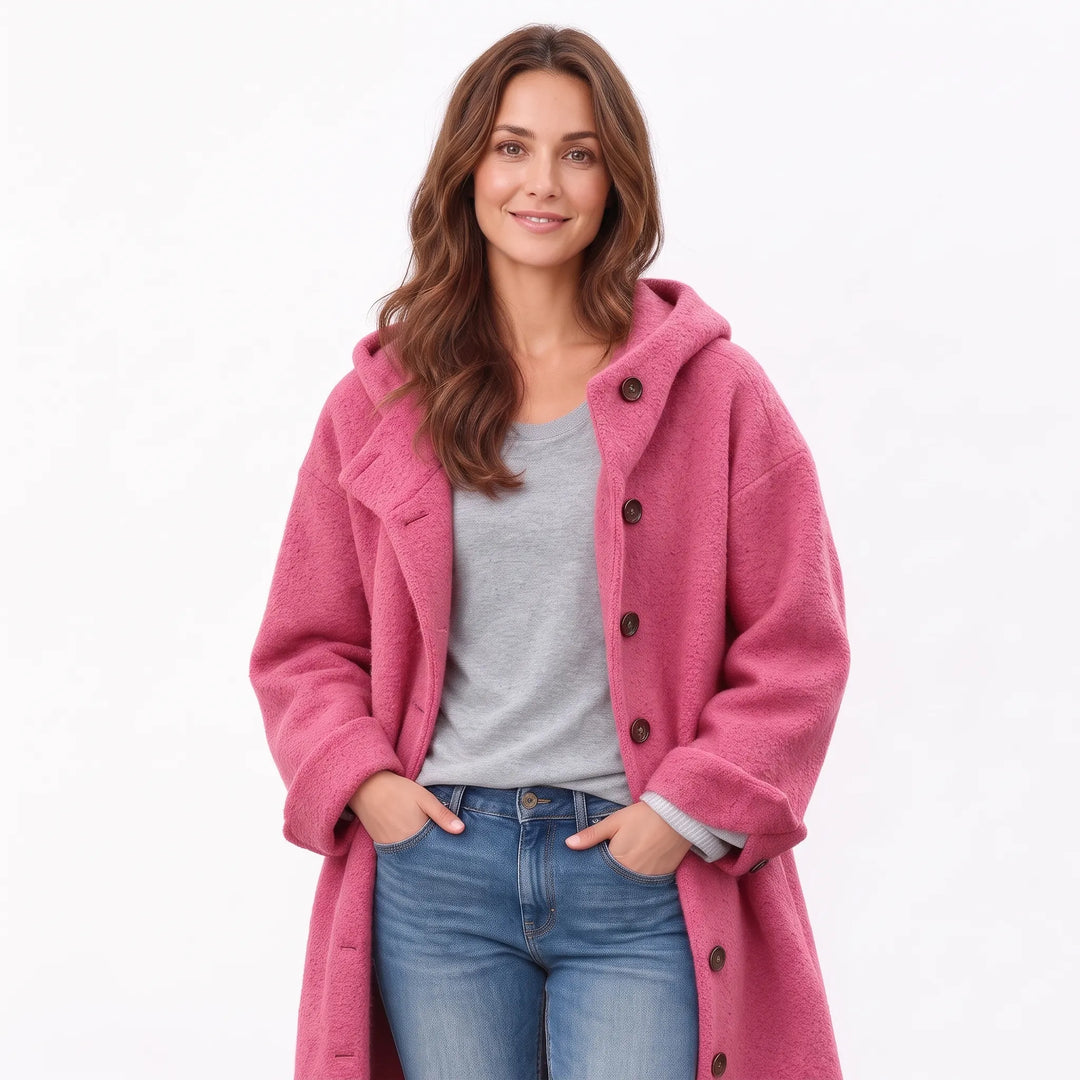 Studio shot of the pink hooded button coat worn open with hands in jeans pockets 16