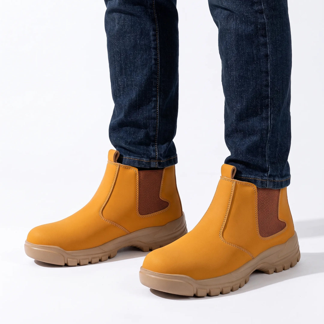 Tan boots with brown elastic panels and light sole worn with dark blue jeans on white 16