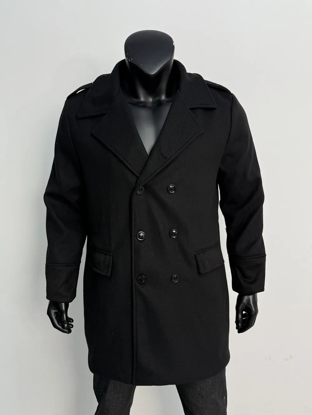 Black double-breasted coat on a mannequin, front view with six black buttons, lapels and flap pockets 16