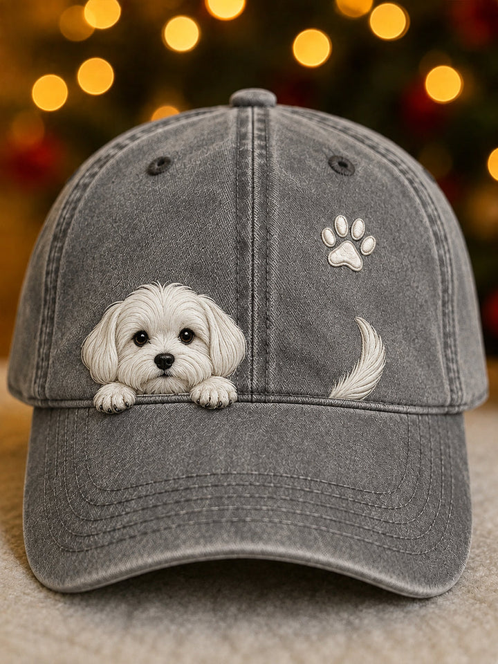 Washed gray baseball cap with a raised white puppy peeking over the brim, a paw print and a tail.
